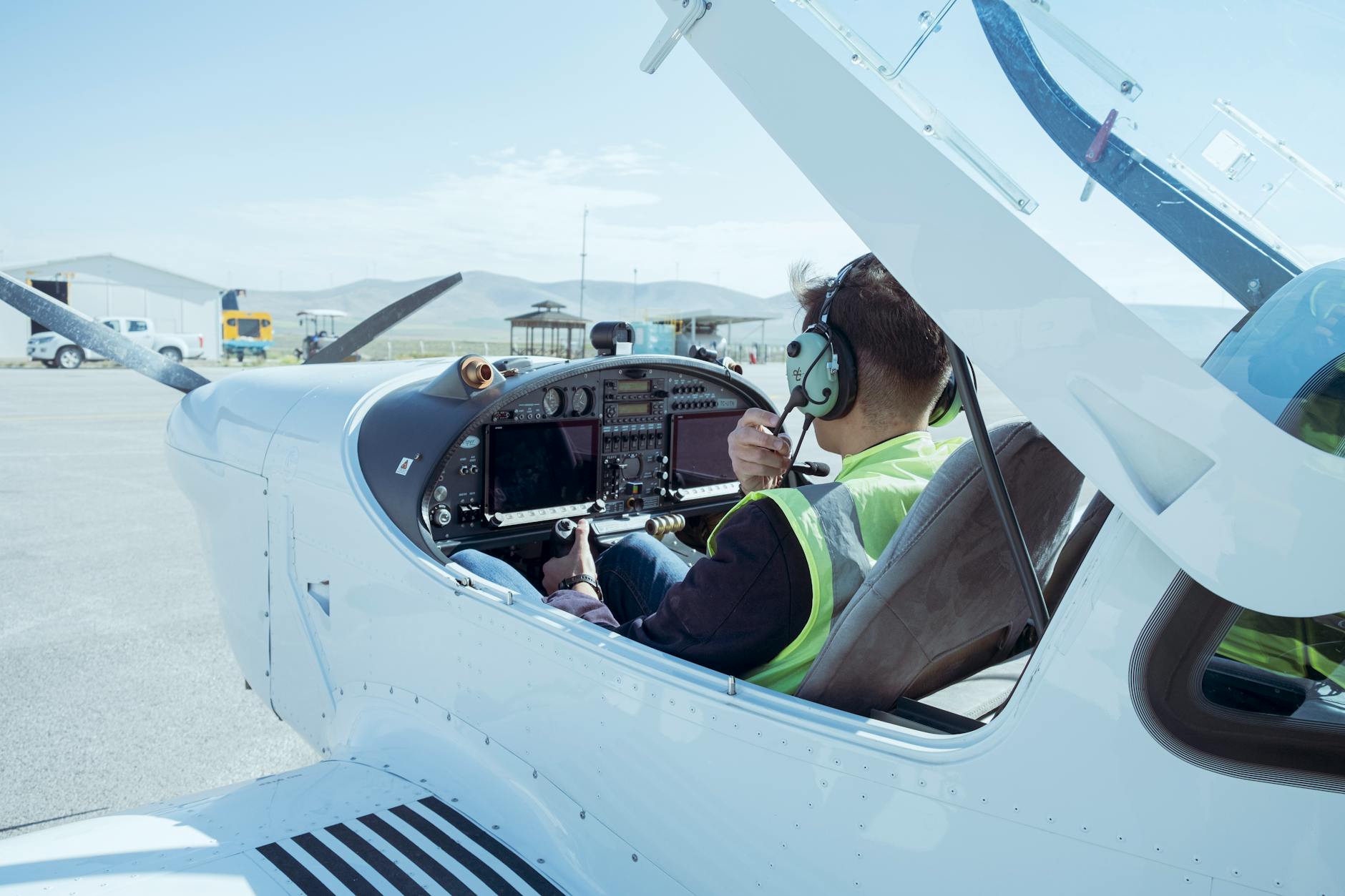 A pilot in the cockpit of a small aircraft readying for flight at Konya Airport, Türkiye.