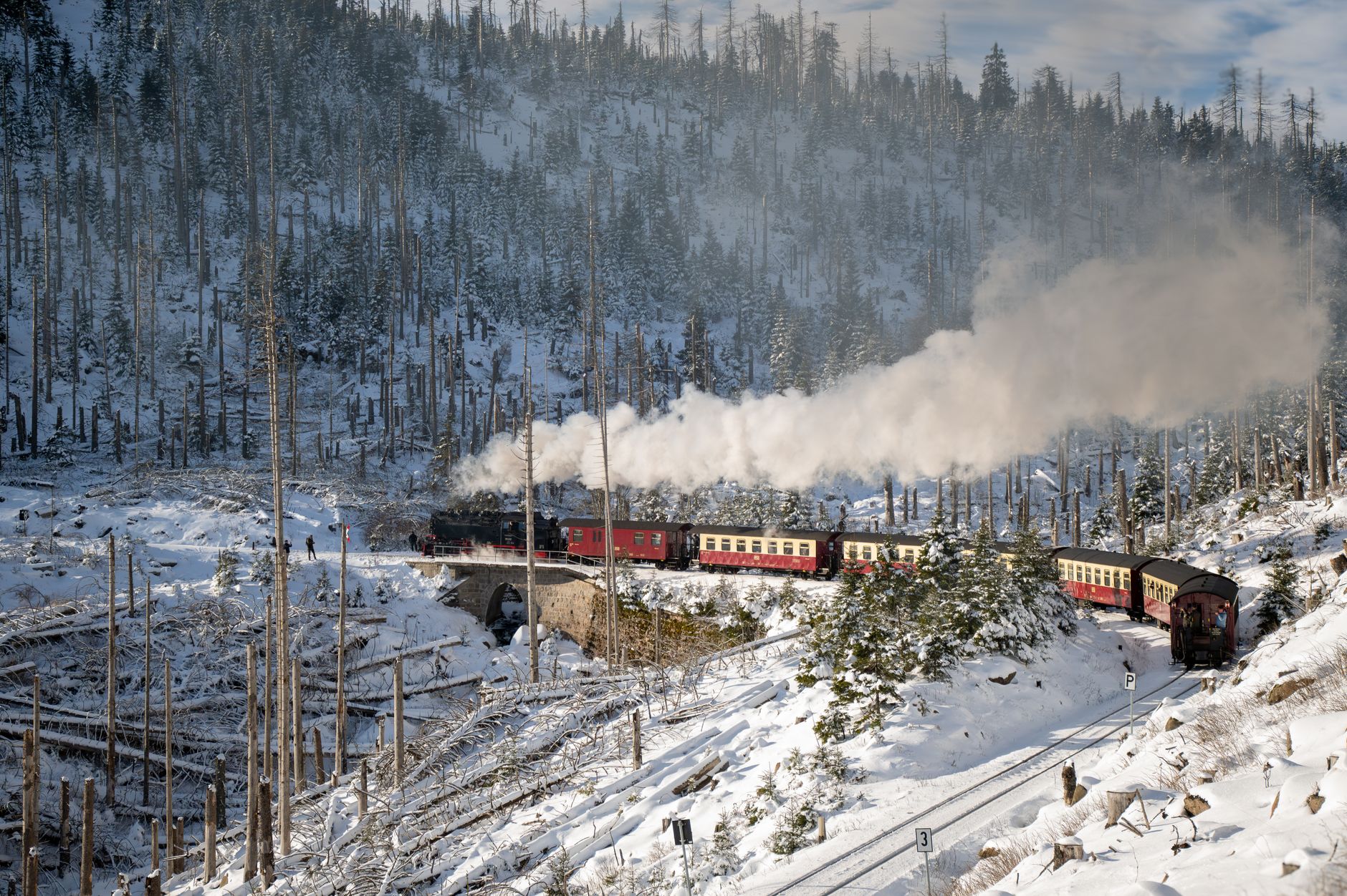 Historic steam train traversing the snowy Harz Mountains in winter.